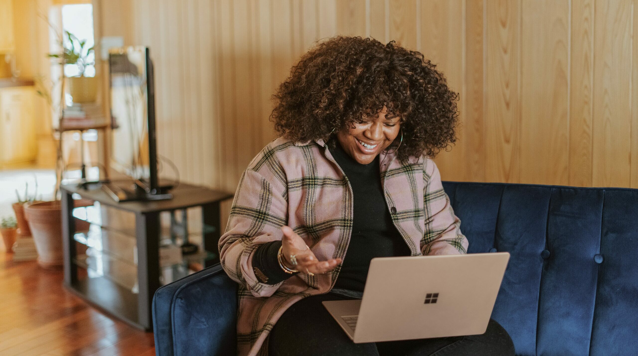 woman sits on the couch using a laptop